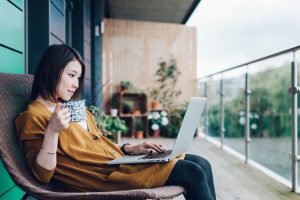 woman on laptop drinking coffee