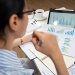 2027 Local Business Advertising Trends: What 514 Owners Told Us Woman sitting on a desk using digital tablet working from home. Businesswoman is working at desk in home. Freelance with laptop and documents. Lifestyle and technology concept