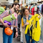 Sporting Goods Retailer Earned $35 for Every $1 Invested with Valpak Couple shopping for outdoor gear in a sporting goods store, holding a backpack, hiking poles and a rain jacket