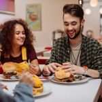 Deals drive dining decisions: Top quick-servce restaurant coupons consumers want Group of friends eating burgers in a restaurant